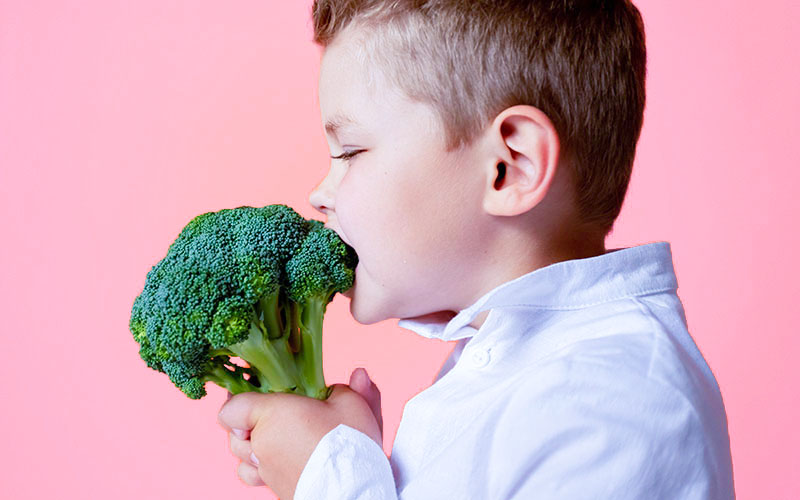 ブロッコリーを食べる少年