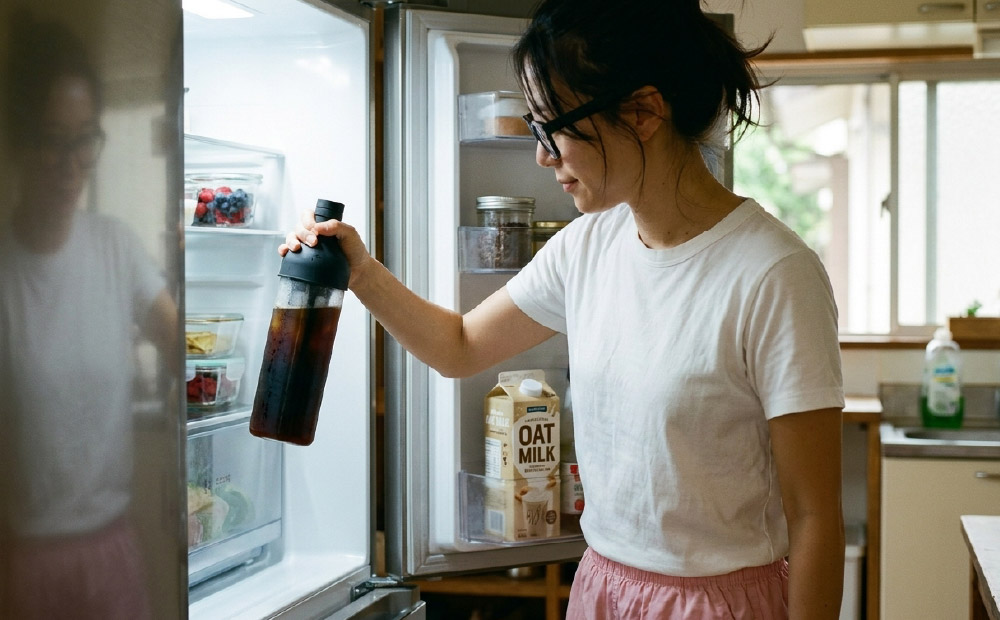 水出しコーヒーのコストを比較_水出しコーヒーを冷蔵庫に入れる女性